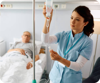 Photo of a nurse standing beside a patient, holding an IV drip to ensure proper administration of medication, showing that InfuSystem syringe pumps are trusted by medical professionals.